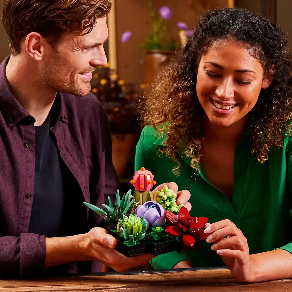 Casal sorrindo com o set LEGO Botanicals Suculentas 10309, destacando o fator Gifting e a montagem compartilhada.