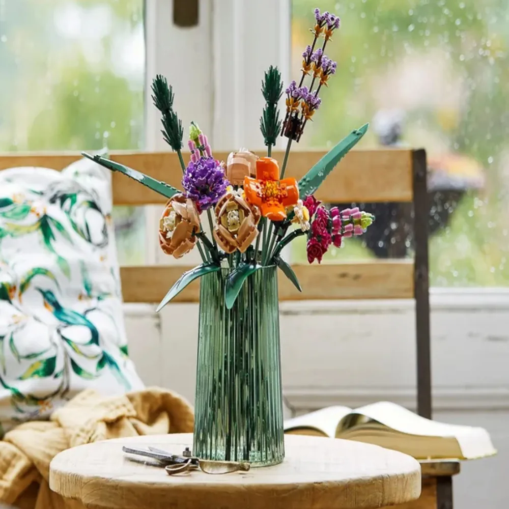 Arranjo do LEGO Buquê de Flores 10280 em vaso verde sobre mesa com cenário aconchegante