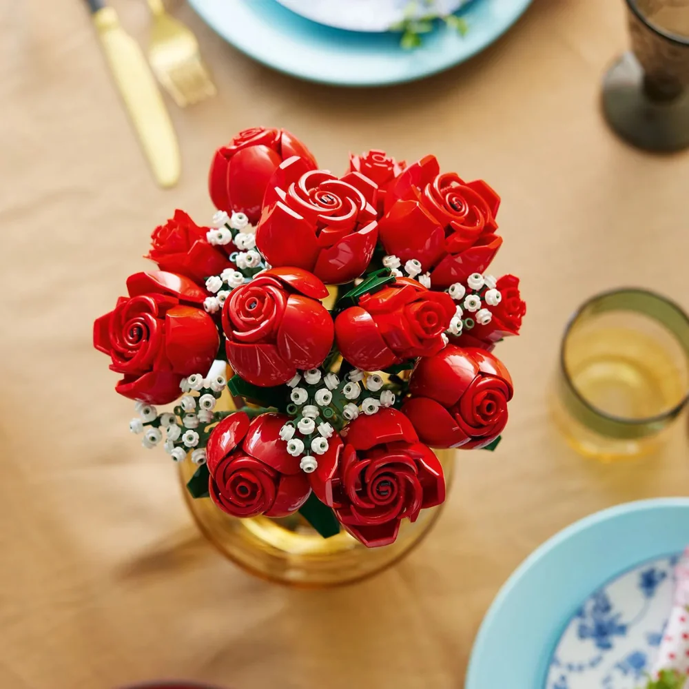 Buquê de Rosas LEGO 10328 em vaso dourado sobre mesa decorada com pratos e taças