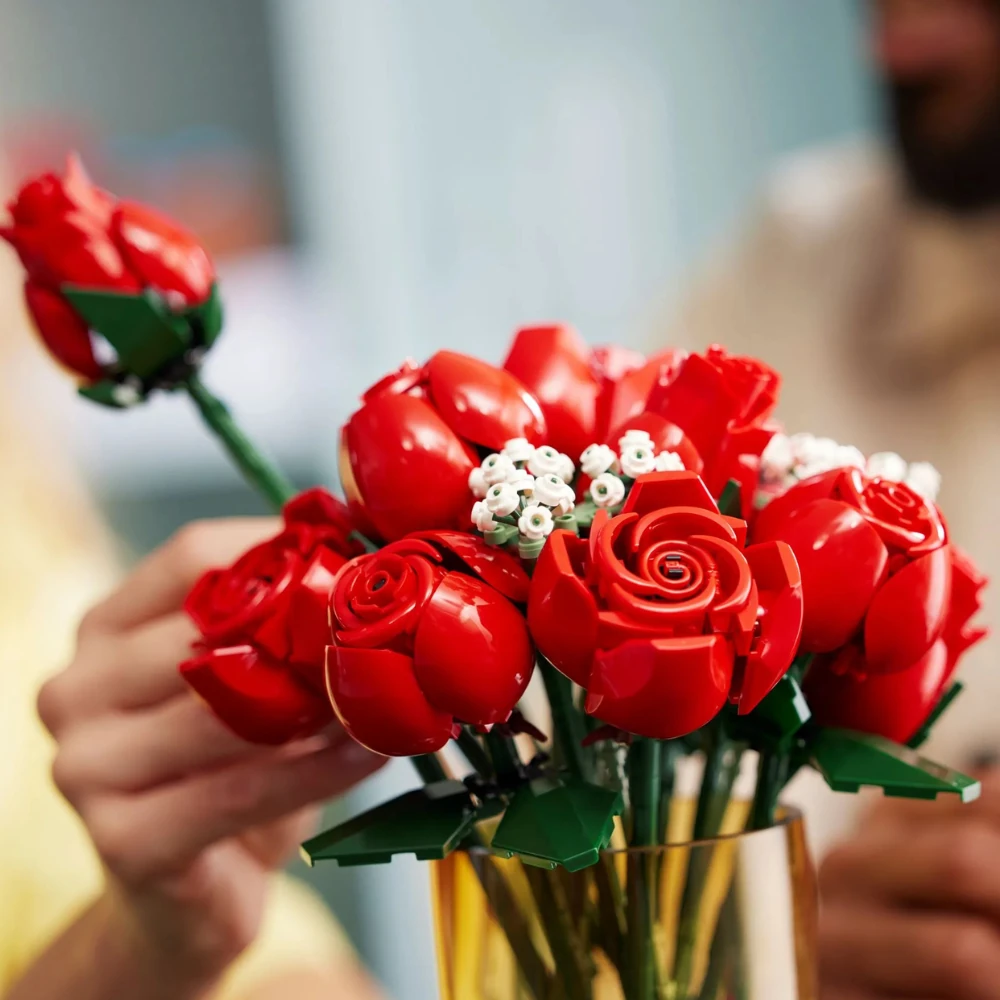 Buquê de Rosas LEGO 10328 em vaso decorativo com pessoas interagindo durante a montagem