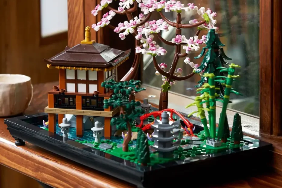 O set LEGO Jardim Tranquilo 10315 exibido em um ambiente de Home Décor, sobre uma prateleira de madeira, com a casa de chá, cerejeiras e ponte vermelha.
