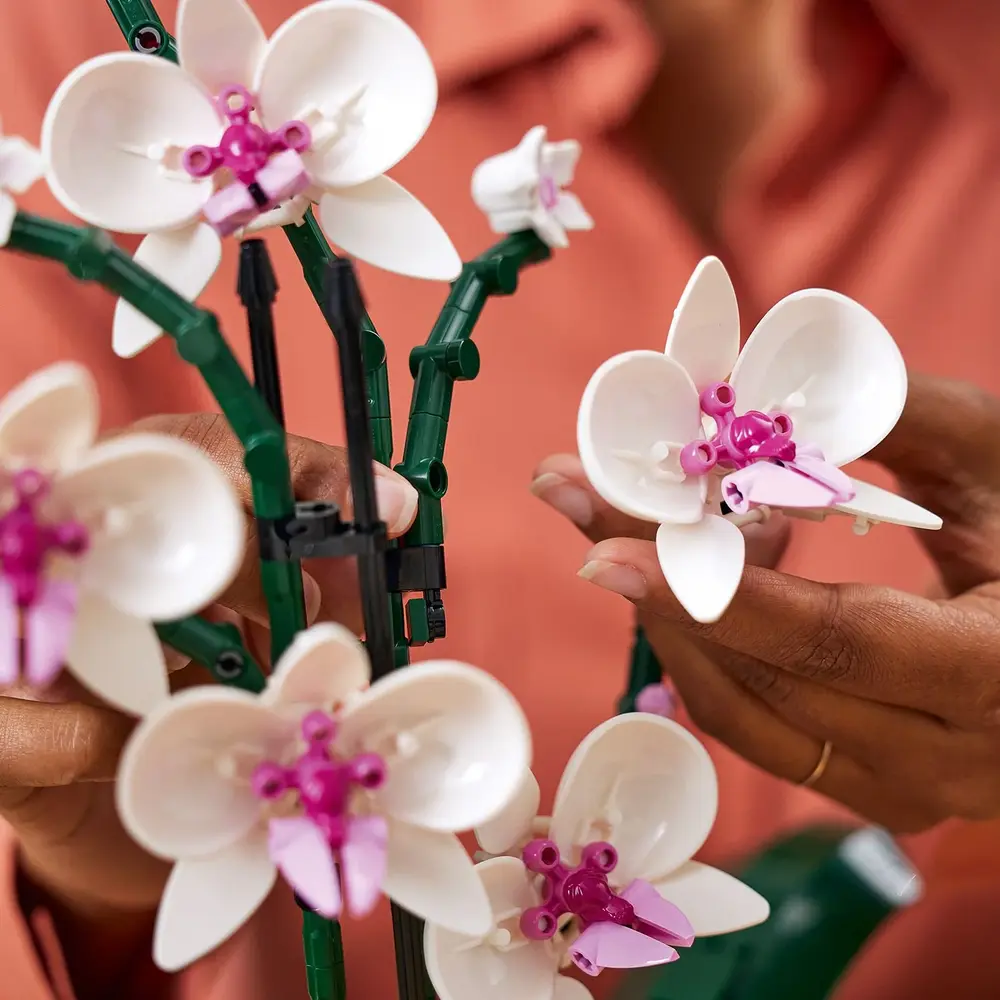 Close-up das flores da LEGO Orquídea 10311, mostrando a peça de escudo impressa no centro das pétalas.