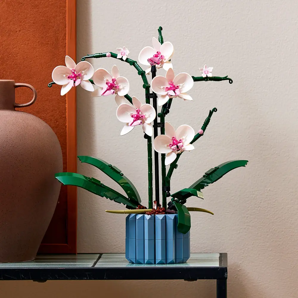 A LEGO Orquídea 10311 montada e exibida como peça central de decoração em um ambiente moderno.