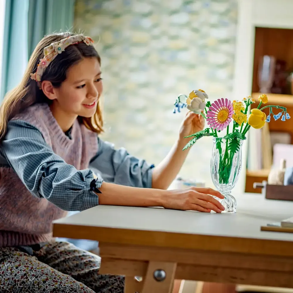 Menina decorando a mesa com o set do Review LEGO Pequeno Buquê Ensolarado
